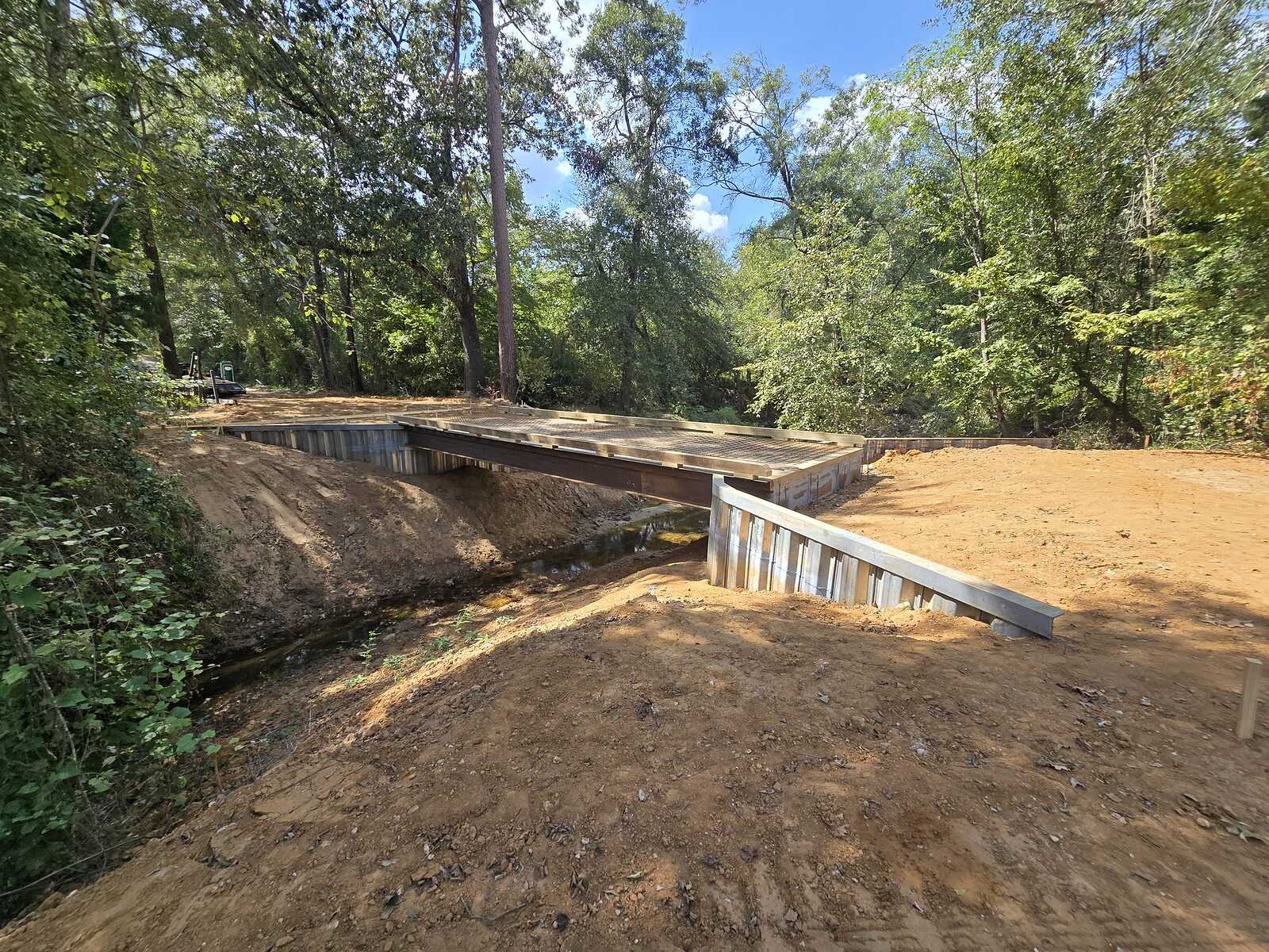Curved galvanized steel sheet-pile bulkhead with fresh backfill on a Texas shoreline