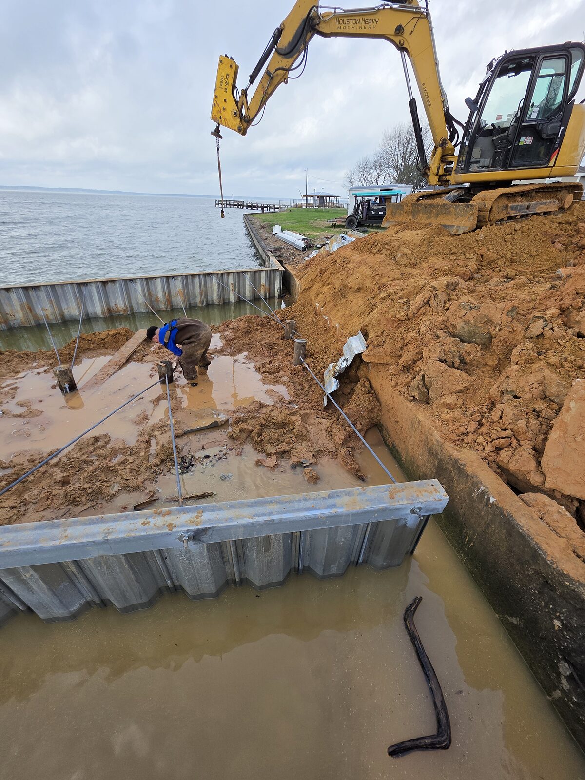 Dredged material pumped behind a new steel bulkhead to reclaim and raise upland on a Texas waterfront