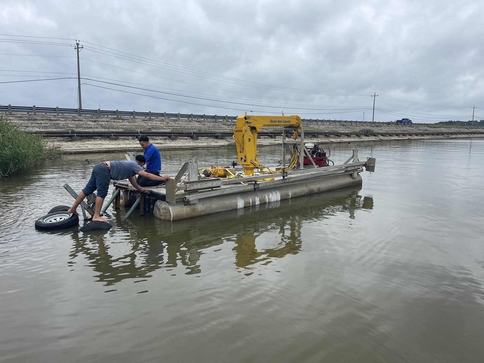 Shore Tech crew operating an excavator-mounted dredge from a sectional barge on a Texas lake