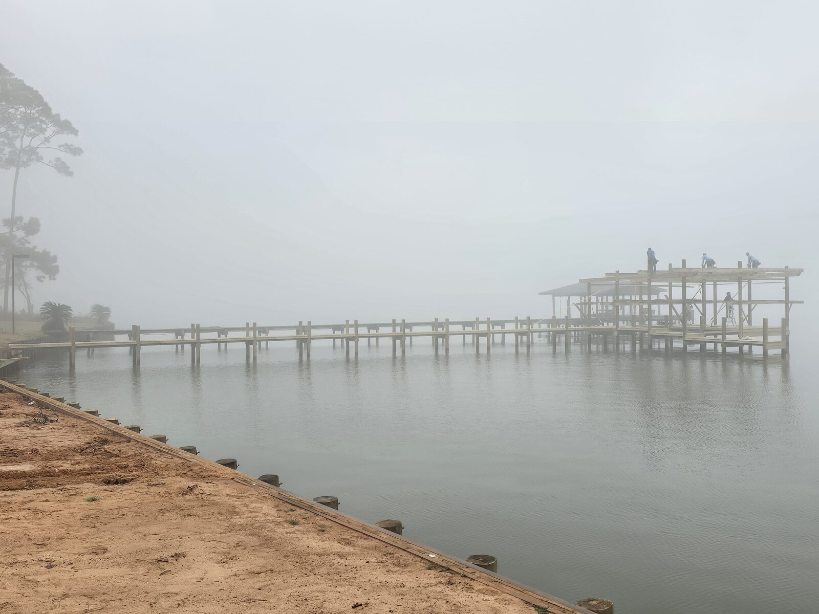 Shore Tech crew building a pier substructure over open water at dawn