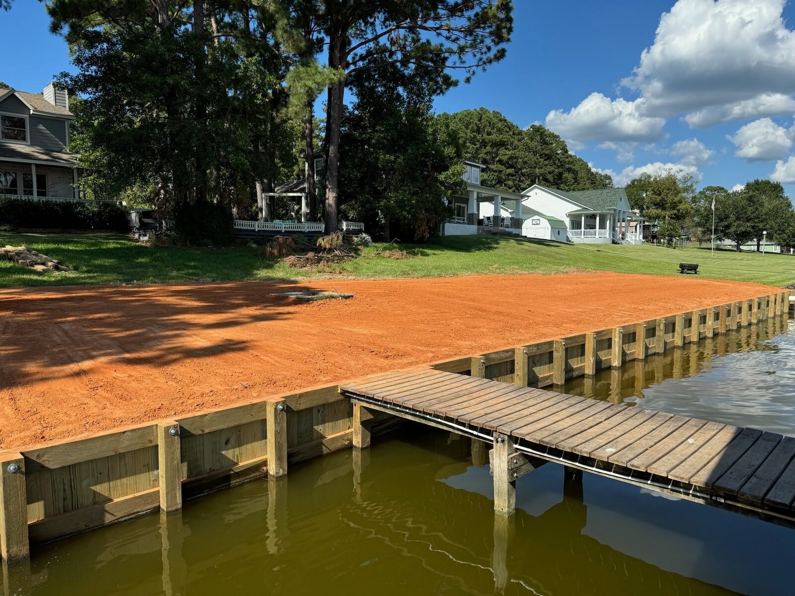 Completed timber shoreline bulkhead and pier along the Milburn, Texas waterfront