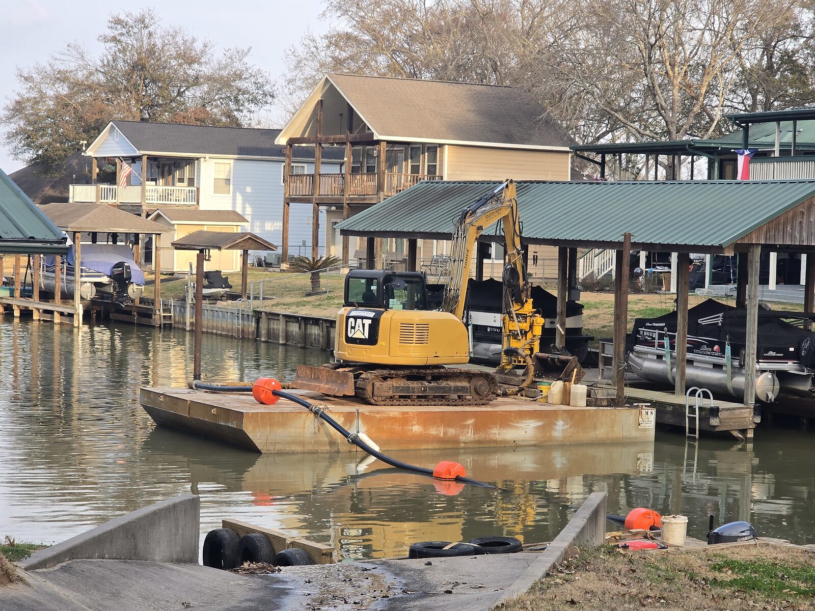 Lakefront home with a boat lift and dock at dusk on a Texas lake